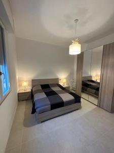 Schlafzimmer mit einem schwarzen und weißen Bett und einem Spiegel in der Unterkunft Appartamento a pochi passi dal mare in Bellaria-Igea Marina