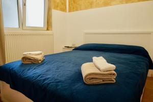 sypialnia z niebieskim łóżkiem i ręcznikami w obiekcie Vila Alfredo w Krajowej
