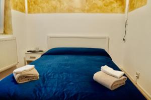 Un dormitorio con una cama azul con toallas. en Vila Alfredo, en Craiova