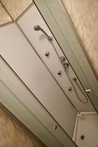 a shower in a bathroom with white walls at Vila Alfredo in Craiova