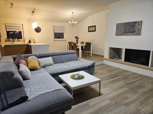 un soggiorno con divano blu e tavolo di Apartment Robi a Umag (Umago)