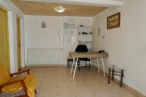 a room with a desk and a table and a shelf at Cazare Alfredo in Craiova