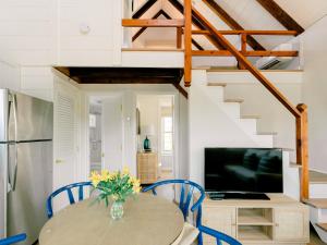 a kitchen and dining room with a table and blue chairs at The Cottages & Lofts in Nantucket