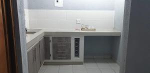 a white kitchen with a sink and a counter at Tsamatiku Villa Guesthouse in Hazyview