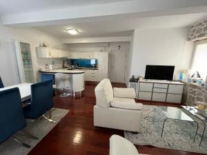 a living room with white furniture and a kitchen at Apartments Villa De Blue in Bol