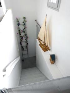 eine weiße Treppe mit einem Holzboot an der Wand in der Unterkunft L'avocette élégante in Saint-Valery-sur-Somme