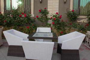 uma mesa e duas cadeiras e rosas vermelhas em Museum Guest House-Muzey Ailəvi Qonaq Evi em Sheki