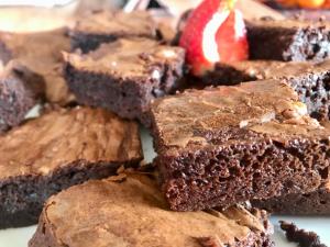 a pile of chocolate brownies with a strawberry in the background at Enam Room in Kojsko