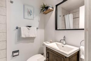 a bathroom with a sink and a toilet and a mirror at Hôtel Automatisé Manoir des Remparts in Quebec City