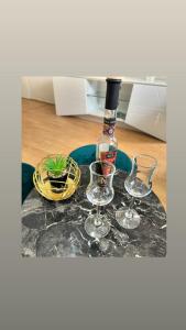 a bottle of wine and two glasses on a table at Apartman SunShine in Trebinje