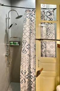 ein Bad mit einem Duschvorhang neben einer Tür in der Unterkunft Mastoris Mansion in Hydra