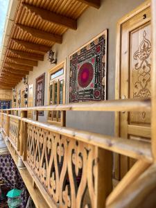 - un balcon en bois avec un tapis sur le mur dans l'établissement Old Palace Hotel, à Samarcande