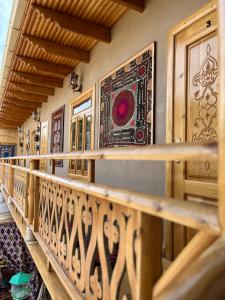 a wooden balcony with a rug on the wall at Old Palace Hotel in Samarkand