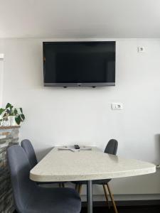 un tavolo con sedie e una televisione su una parete di JT Apartma a Bled