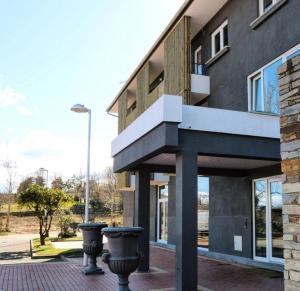 un edificio con dos cubos de basura delante de él en Boutique Wine Hotel Panorama en Macedo de Cavaleiros