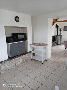 a kitchen with a table and a microwave at Gite La Hulotte in Saint-Laurent-sur-Mer