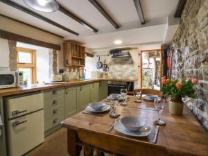 Gallivantin Cottage في ليبرن: مطبخ مع طاولة خشبية مع كؤوس للنبيذ