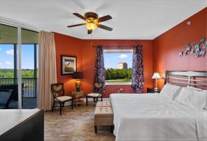 1 dormitorio con paredes de color naranja y 1 cama con ventilador de techo. en Santo Amaro Unit 301B at Lost Key Golf & Beach Club, en Pensacola