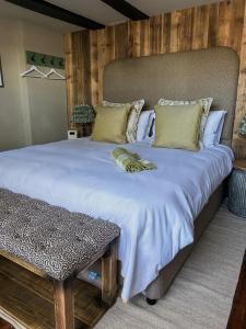 un grande letto con lenzuola e cuscini bianchi di The Fitz Farmhouse a Swynnerton
