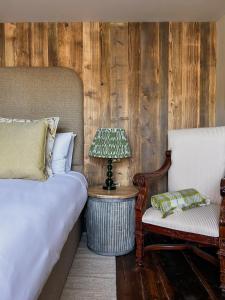 sypialnia z łóżkiem, krzesłem i lampką w obiekcie The Fitz Farmhouse w mieście Swynnerton