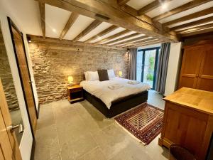 a bedroom with a bed and a stone wall at The Cart House - Rural Retreat in Hereford