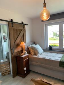 a bedroom with a bed and a window and a lamp at B&B Villa Navy in Koksijde