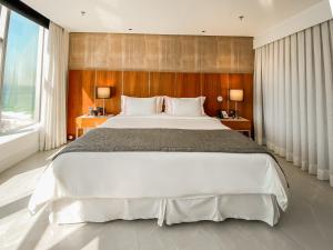 a bedroom with a large bed and a large window at Hotel Nacional Rio de Janeiro - OFICIAL in Rio de Janeiro