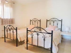 - une chambre avec un lit en métal noir et des oreillers roses dans l'établissement Home Garden, à Siniscola