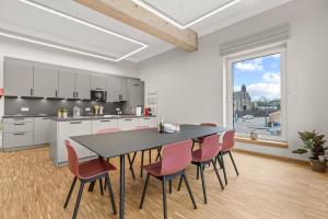 巴斯查哈吉的住宿－Lénger Schoul，厨房配有黑色桌子和粉红色椅子