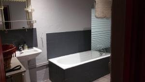 ein Badezimmer mit einer Badewanne und einem Waschbecken in der Unterkunft L'AUBRIETE in Recoules-dʼAubrac