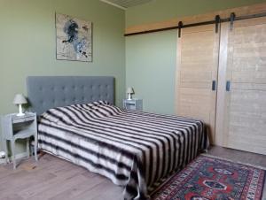 a bedroom with a bed with a striped blanket at L'AUBRIETE in Recoules-dʼAubrac