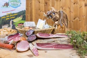 un tavolo con carne e una statua di mucca sopra di Stofnerhof Alpenherz a Sarentino (Sarntal) Altre 15 foto