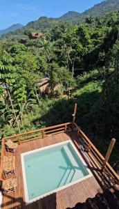 a swimming pool on a deck with a view of a mountain at Pousada Encontro das Águas in Trindade