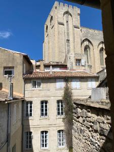 um edifício antigo com uma torre e uma igreja em L'Enclave em Avignon