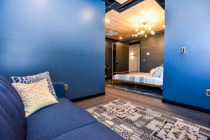 a living room with a blue couch and a bedroom at Indigo Pass Boutique Hotel in Middletown