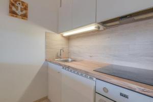 uma cozinha com um lavatório e uma bancada em Ferienpark-Sierksdorf-Haus-5-WE-595 em Sierksdorf