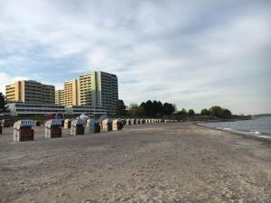 uma praia com uma fila de guarda-sóis e edifícios em Ferienpark-Sierksdorf-Haus-5-WE-595 em Sierksdorf