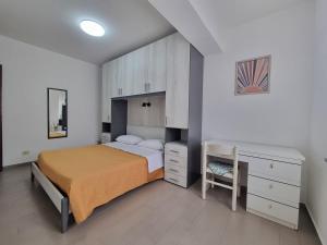 1 dormitorio con 1 cama, vestidor y escritorio en Villaggio Camping Lungomare, en Cropani