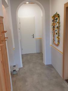 um corredor com uma porta branca e um espelho em Pension Weitblick 