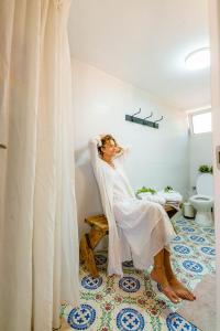 a woman sitting on a bench in a bathroom at Cactus - צימר במדבר in Arad