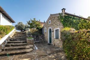 a stone house with stairs leading up to a door at La Casettina del Forno in Santa Maria di Castellabate