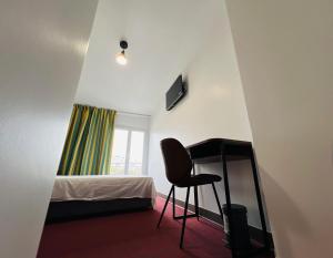 1 dormitorio con escritorio, 1 cama y 1 silla en Auberge de Bagneux en Bagneux