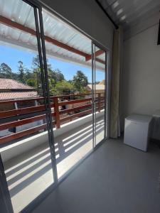 um quarto com uma varanda com portas de vidro deslizantes em Pousada Uchimura em Itapecerica da Serra