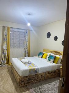 Cozy 1br apartment in King’ong’o-Nyeri في نيري: غرفة نوم بسرير مع مخدات صفراء و زرقاء