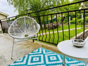 ein weißer Stuhl und ein Tisch auf einem Balkon in der Unterkunft Maison Le M - Disneyland Parking in Chessy