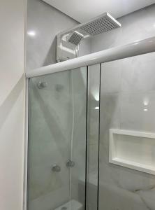 La salle de bains est pourvue d'une douche avec une porte en verre. dans l'établissement Studio 2 Vila Clementino, à São Paulo