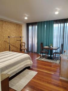 ValadaresにあるQuarto próximo a praia Vila Nova de Gaiaのベッドルーム1室(ベッド1台、テーブル、椅子付)