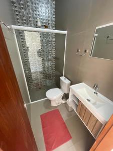 a bathroom with a shower and a toilet and a sink at Pousada Uchimura in Itapecerica da Serra