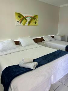 duas camas num quarto de hotel com toalhas em Nautillus Hotel na Parnaíba