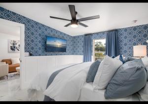 a bedroom with a bed with a ceiling fan at Chic Naples cottage 7 min from the beach in Naples